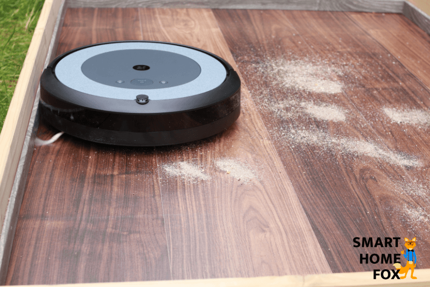iRobot Roomba i3 Plus reinigt Sand auf einem Laminatboden